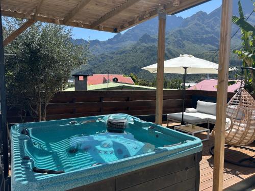 a hot tub on a deck with a view of mountains at Le djebel in Cilaos