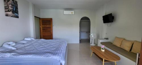 a bedroom with a bed and a couch and a table at Marine House Koh Tao in Koh Tao