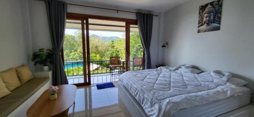 a bedroom with a bed and a balcony with a view at Marine House Koh Tao in Koh Tao