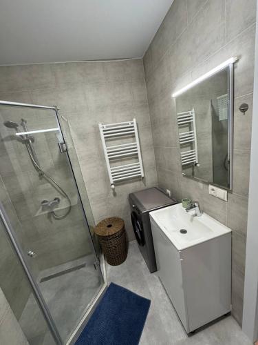 a bathroom with a shower and a sink and a toilet at NovaStay Apartments in Batumi