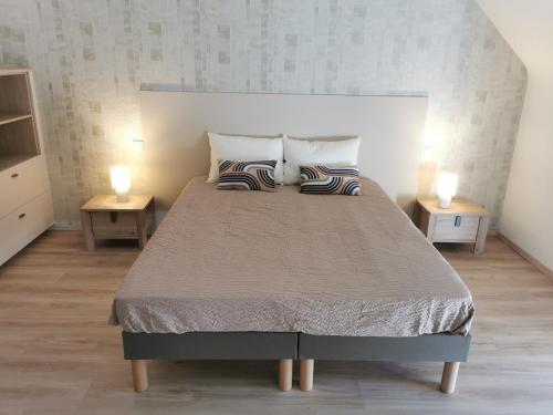 Un dormitorio con una cama grande con dos lámparas sobre mesas. en Ty Coz Hermine, en Riec-sur-Bélon