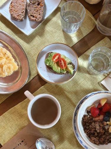 een tafel met borden eten en een kopje koffie bij Casa Merceditas in Corçà