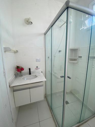 a bathroom with a glass shower and a sink at Apê 126 - Vista Mar in São Vicente
