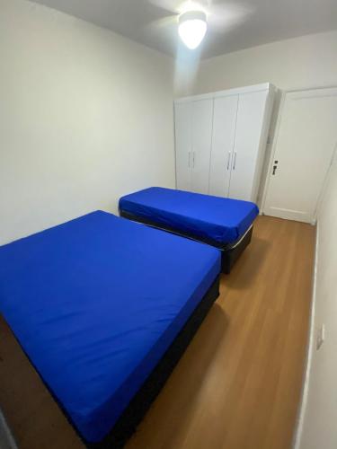a small room with a blue bed in it at Apê 126 - Vista Mar in São Vicente