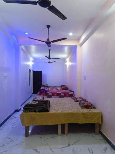 a room with two beds and a ceiling fan at Maa janki paying guest house in Ayodhya