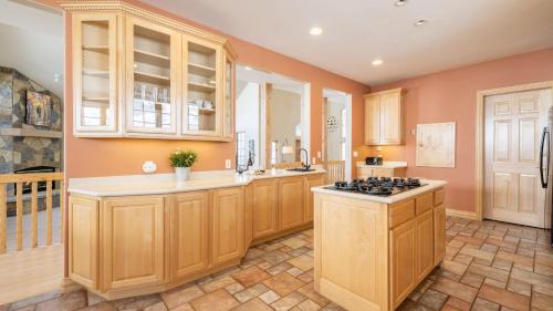 a kitchen with wooden cabinets and a stove top oven at Vail View by AvantStay Minutes from Beaver Creek in Dowds Junction