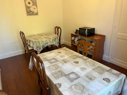 a room with two tables and a table and chairs at Le Pontet in Miramont-de-Guyenne