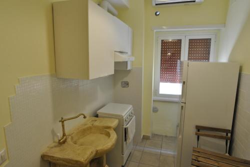 małą łazienkę z umywalką i lodówką w obiekcie Roma Tourist House w Rzymie