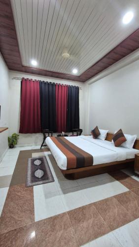 a large bed in a room with red curtains at Hotel Dhola Maru in Kota