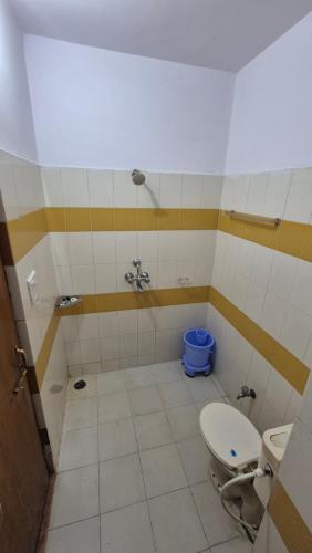 a bathroom with a toilet and a blue bidet at Hotel dhola maru in Kota