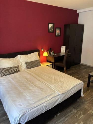 a bedroom with a large bed and a desk at Hotel Parc & Lac in Montreux