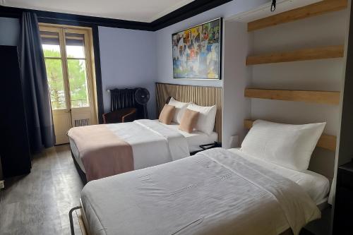 a hotel room with two beds and a window at Hotel Parc & Lac in Montreux