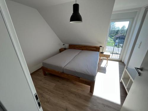 a small bedroom with a bed and a window at Ferienhaus Ankerplatz in Timmel
