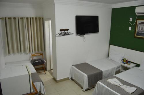 a room with two beds and a flat screen tv at Hotel Cuca Fresca in Cotia