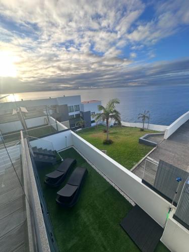 a balcony with two chairs and a view of the ocean at Madeira Home at Cliff Residence in Santa Cruz
