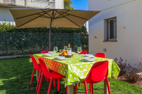 a table with red chairs and a yellow and white polka dot table cloth at Casa Augusta in Verbania