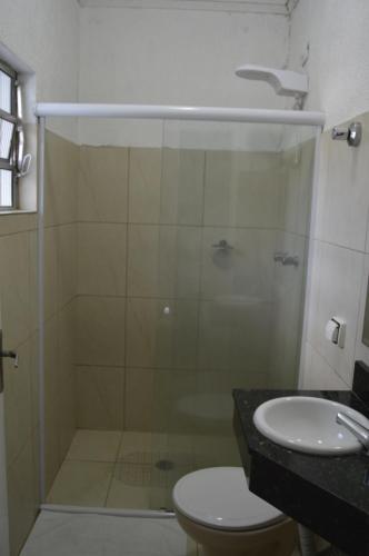 a bathroom with a shower and a toilet and a sink at Hotel Cuca Fresca in Cotia