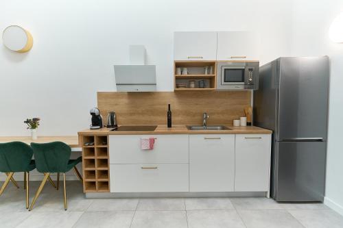 eine Küche mit weißen Schränken und einem Kühlschrank in der Unterkunft Apartments Lukas 2 in Zadar