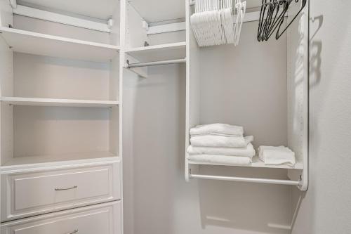 Armario blanco con estanterías blancas y toallas en Pet-Friendly Lakeland Family Oasis with Game Room, en Highland City