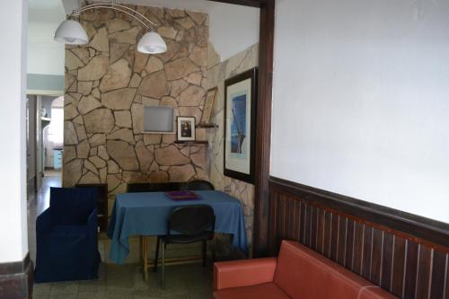 Zimmer mit einem blauen Tisch und einer Steinmauer in der Unterkunft Casa Urbana in Villa Progreso