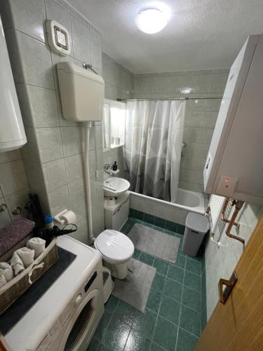 a bathroom with a toilet and a sink and a shower at Apartman Deja vu in Livno