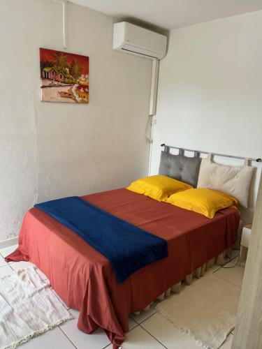 a bedroom with a bed with a red and blue blanket at villa Rony in Port-Louis
