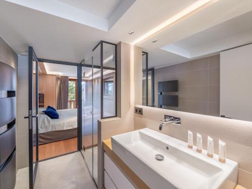 a bathroom with a white sink and a bedroom at Triplex de charme avec cheminée, balcon et parking à Courchevel Chenus, proche des pistes - FR-1-564-90 in Courchevel