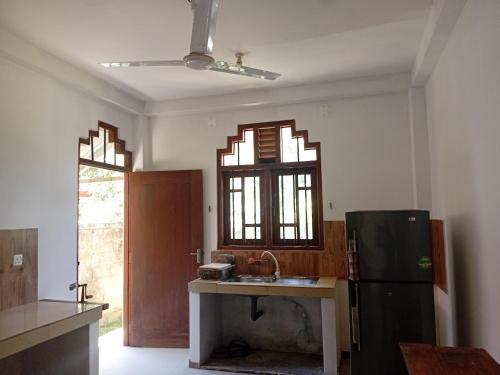 a kitchen with a sink and a refrigerator at Bliss Villa in Kamburugamuwa