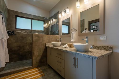une salle de bain avec deux lavabos et une douche dans l'établissement Villa Ballena-luxury Ocean view, à Uvita