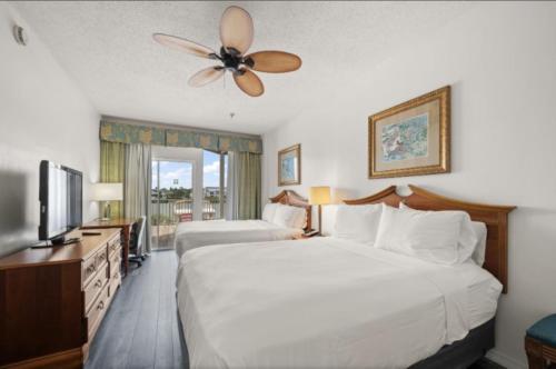 クリアウォーター・ビーチにあるHoliday Inn & Suites Clearwater Beach S-Harboursideのシーリングファン付きのホテルルームのベッド2台
