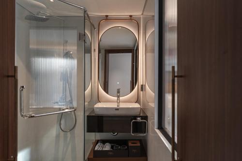 un baño con lavabo y espejo en The Savile, by Harry's, en Hanói