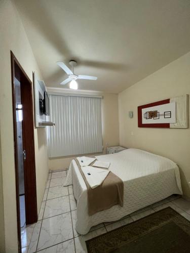 a bedroom with a bed and a ceiling fan at Pousada Vale do Caparaó in Caparaó Velho