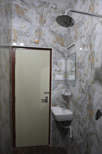 a bathroom with a sink and a mirror at Temple View Residency in Tiruvallūr
