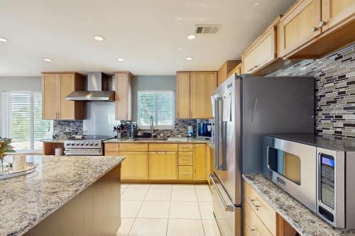 a kitchen with wooden cabinets and stainless steel appliances at Coastal Bliss in Juno Beach