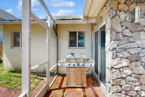 an outdoor kitchen with a sink and a stone wall at Coastal Bliss in Juno Beach
