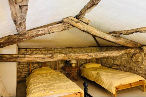 two beds in a room with a stone wall at 2 Bedroom Cottage - Sleeps 6 - Pool - Garden in Caylus