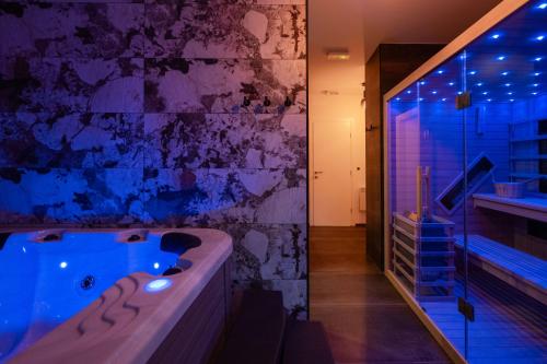 y baño con bañera y ducha a ras de suelo. en Luxury apartments Villa Wood with spa and heated pool NEW, 