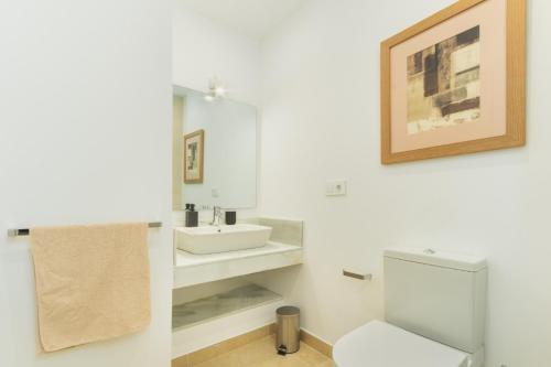 a bathroom with a white toilet and a sink at Lujoso chalet con jardín privado a 300 metros de la playa in Conil de la Frontera