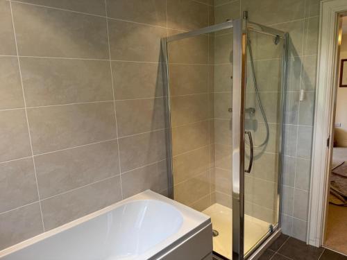 un baño con ducha y bañera en Stonehaven, en Ballycastle