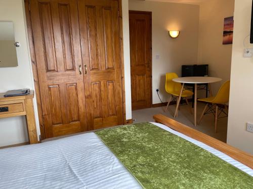 a bedroom with a bed and a table and chairs at Sunset House in Penrith