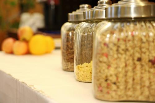 three glass jars filled with food on a counter at Hotel Maxim in Svätý Jur