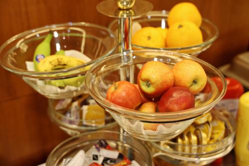 three bowls of apples and oranges and other fruits at Hotel Maxim in Svätý Jur