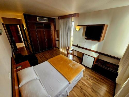 a hotel room with a bed and a flat screen tv at Atalaia Palace Hotel in Guarapuava