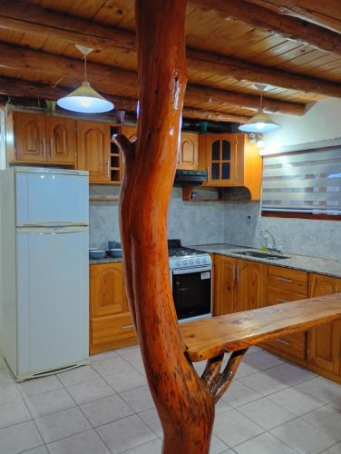 a kitchen with a wooden bench in the middle at Las Palomas in Trevelin