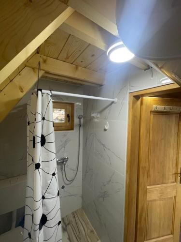 a bathroom with a shower with a white shower curtain at Lake house angela in Kuside