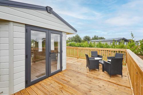 a patio with a table and chairs on a deck at Host & Stay - Deer View Lodge in Pickering