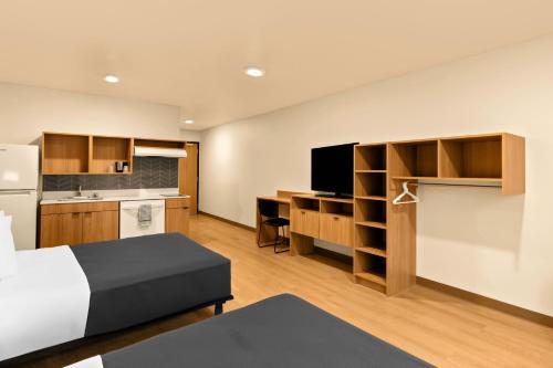 a hotel room with a bed and a kitchen at LivAway Suites Tri-Cities-Richland in Richland
