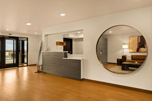 a living room with a mirror and a couch at LivAway Suites Tri-Cities-Richland in Richland