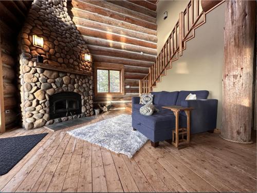 a living room with a blue couch and a stone fireplace at Adams Rest cabin in The Dalles