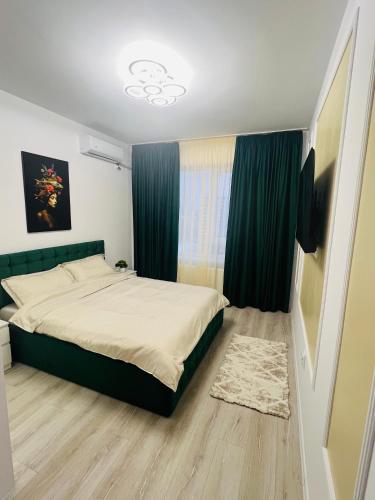 a bedroom with a large bed with blue curtains at RxM HOME CITY in Chiajna